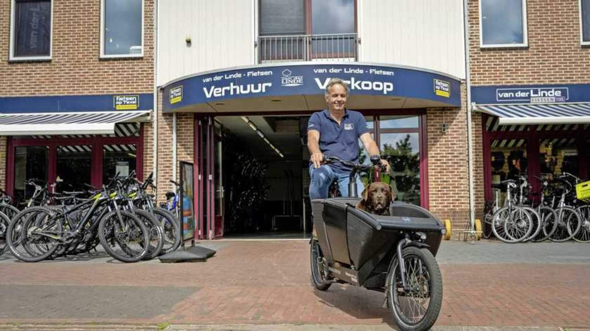 Man op Urban Arrow hondenbakfiets met hond bij fietsenwinkel